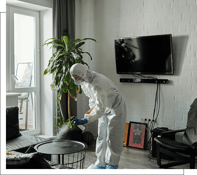 A person in white suit and mask cleaning the floor.